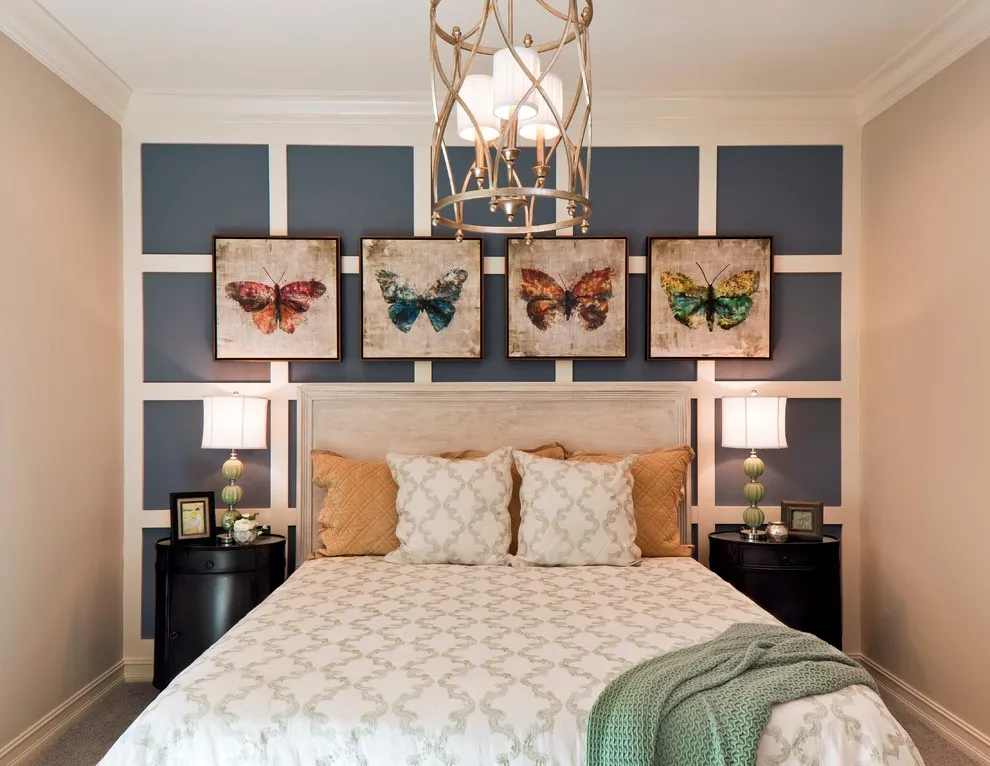 Blue-gray painted rectangles form a grid behind a pale headboard and framed artwork