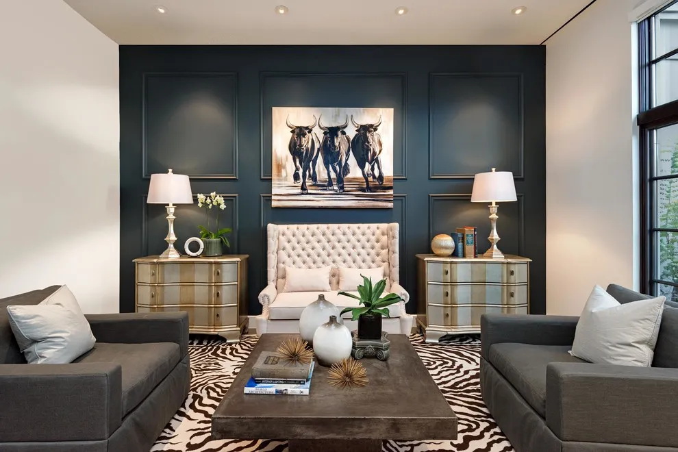 Dark rectangular wall panels frame a pale tufted seat and artwork between gray sofas