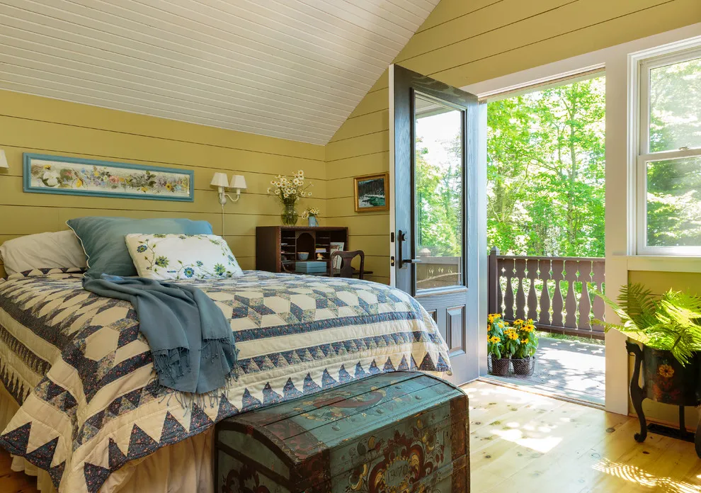Yellow horizontal boards cover a bedroom wall beside an open garden doorway