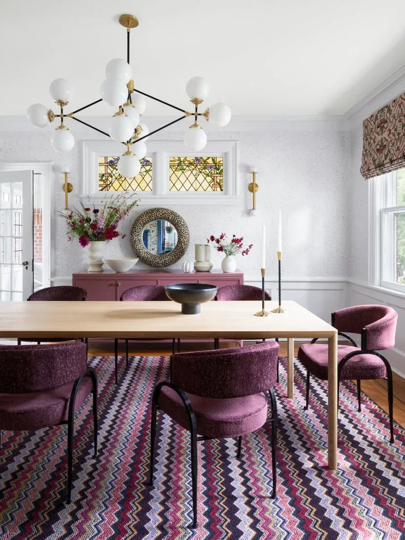 White dining wall panels behind purple upholstered chairs and a purple sideboard on a zigzag rug