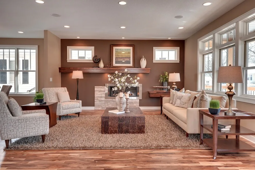 Pale patterned chairs sit opposite a light sofa beside a reddish-brown wall