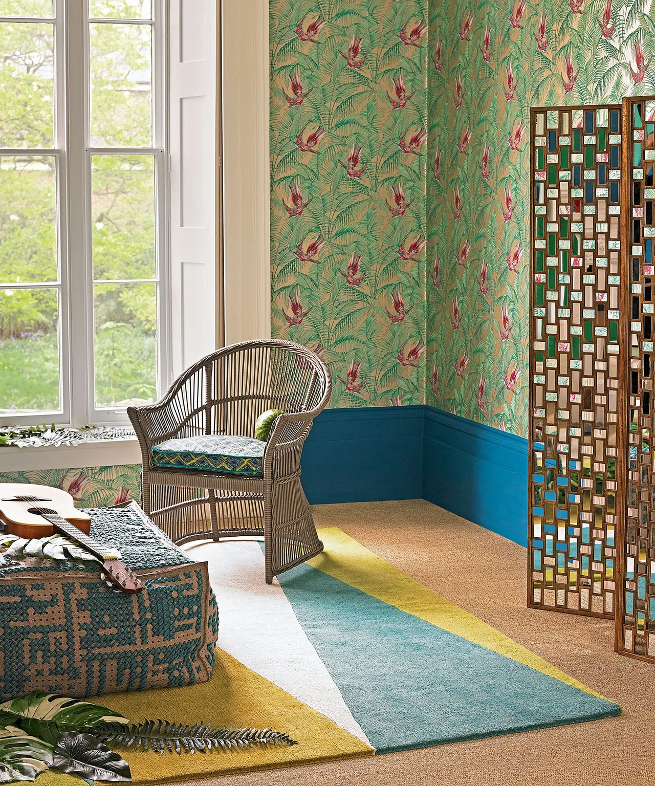 Green patterned walls surround woven seating beside a blue-and-yellow rug.