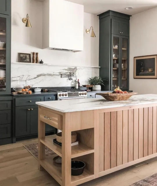 A pale slatted timber island stands in front of tall charcoal cabinets.