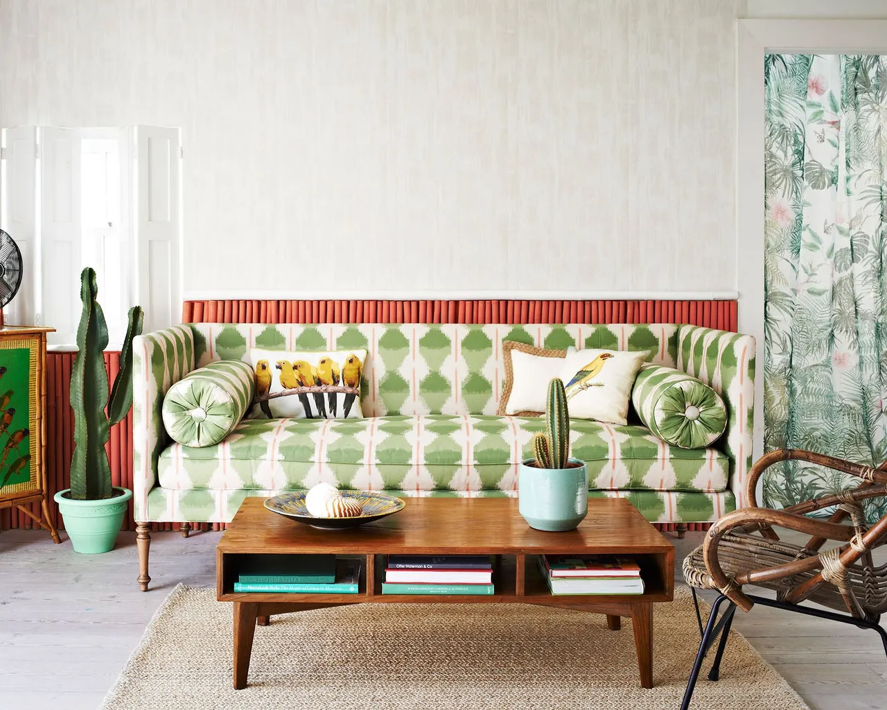 A green-and-white patterned sofa sits beside woven furniture and a timber coffee table.