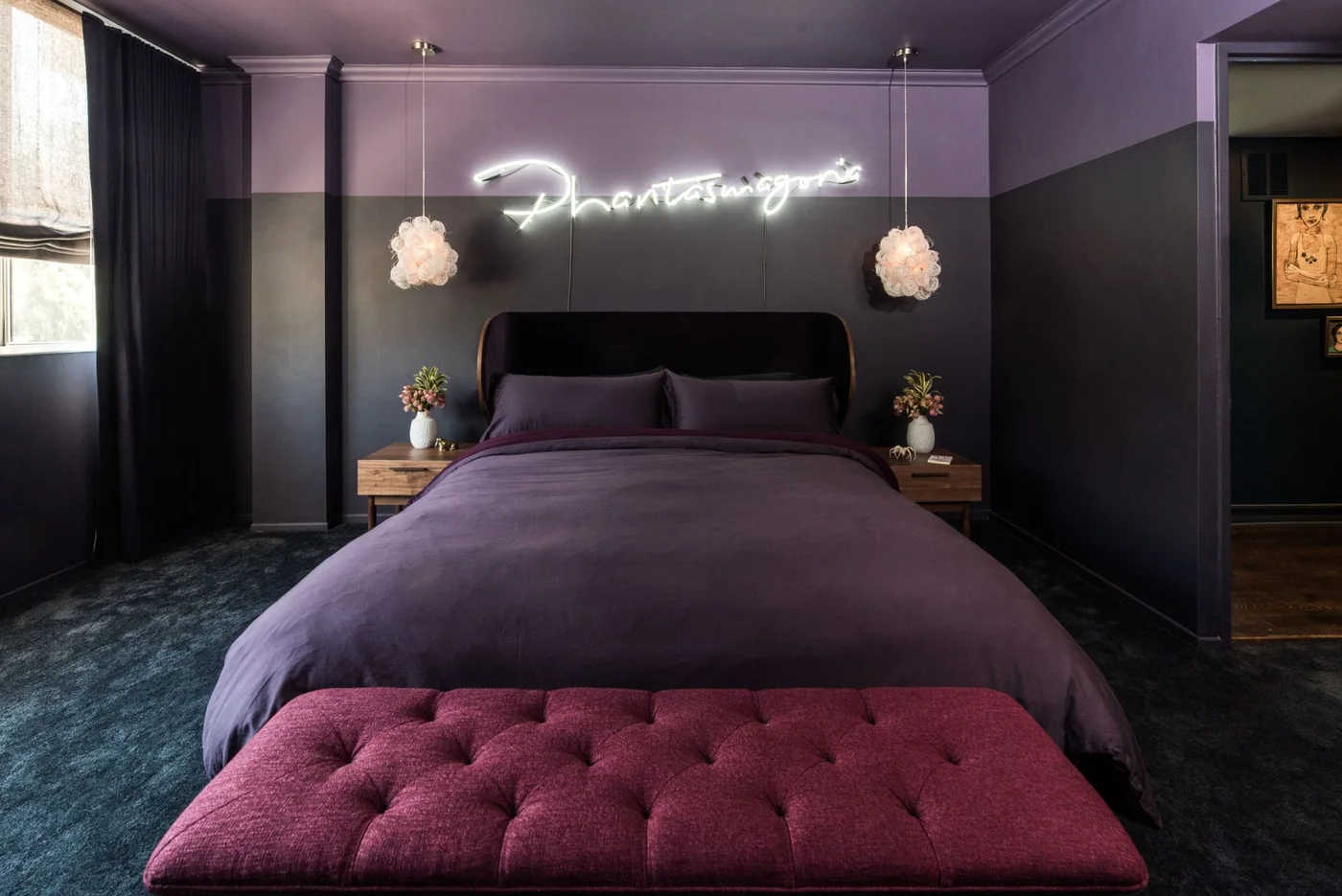 A purple ceiling and upper walls surround a dark headboard, purple bedding, a burgundy tufted bench and two hanging lights
