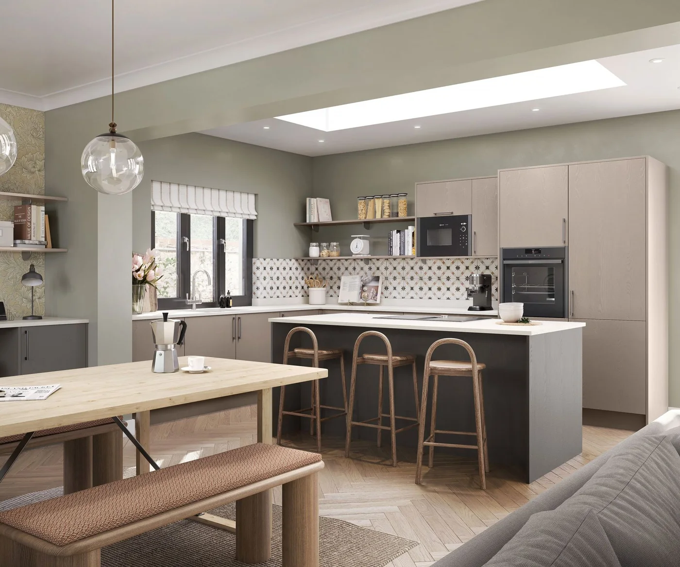 A wooden dining table with an upholstered bench stands beside a gray kitchen island, pale cupboards and a roof light