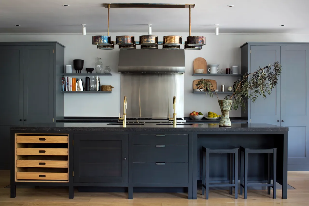 Navy lower cabinets sit beneath gray tall storage and open shelves