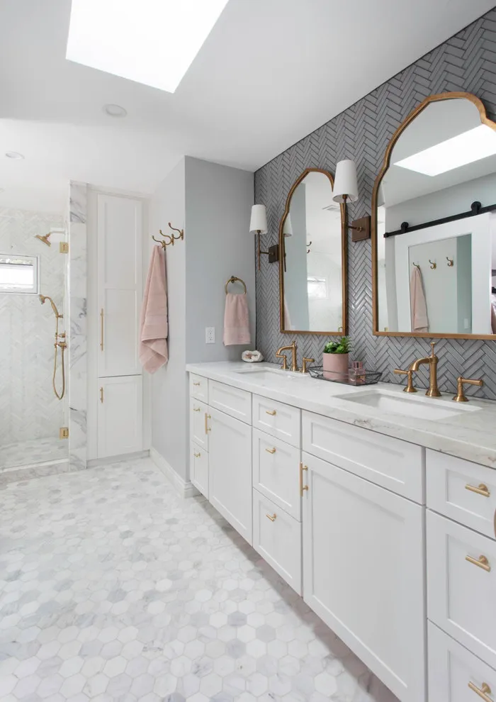 A light bathroom floor sits beside patterned walls and a long white vanity