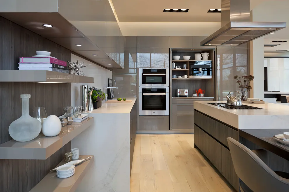 Gray-taupe slab cabinets and open shelves beside pale counters and a wood floor