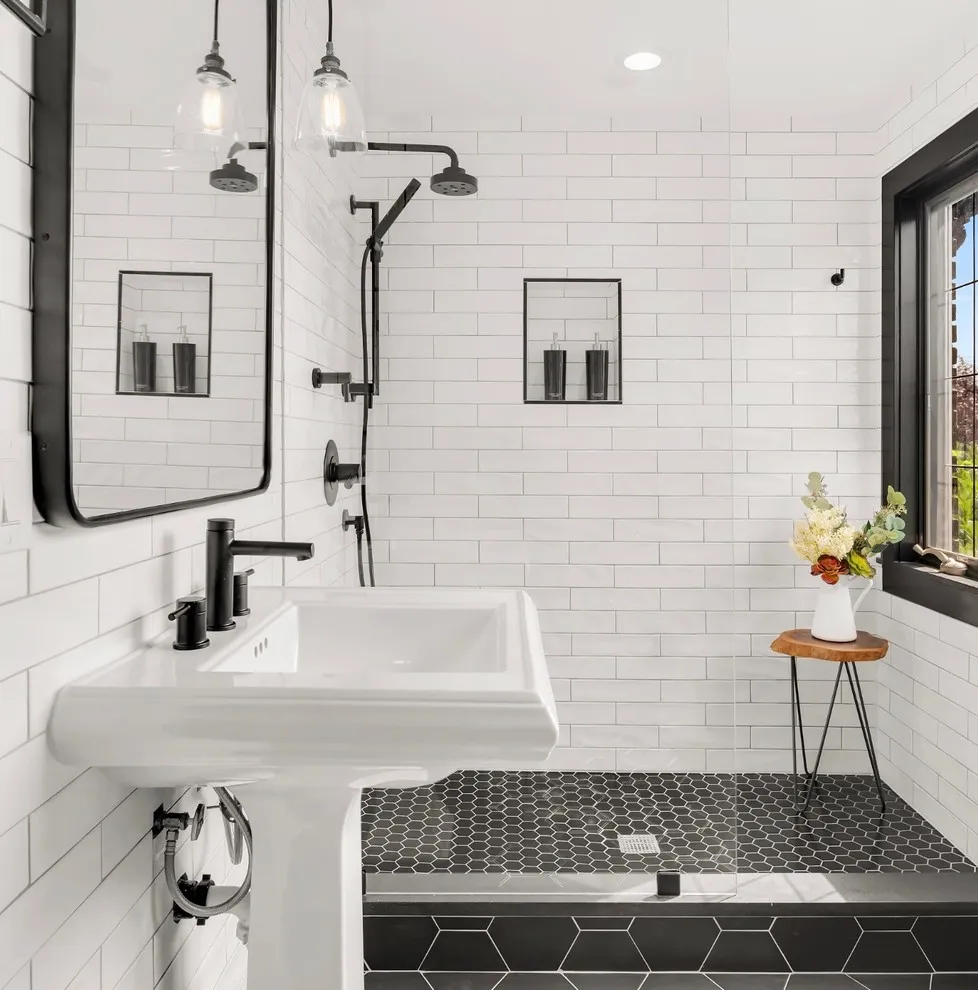 Small dark tiles cover the shower floor beside white rectangular wall tiles
