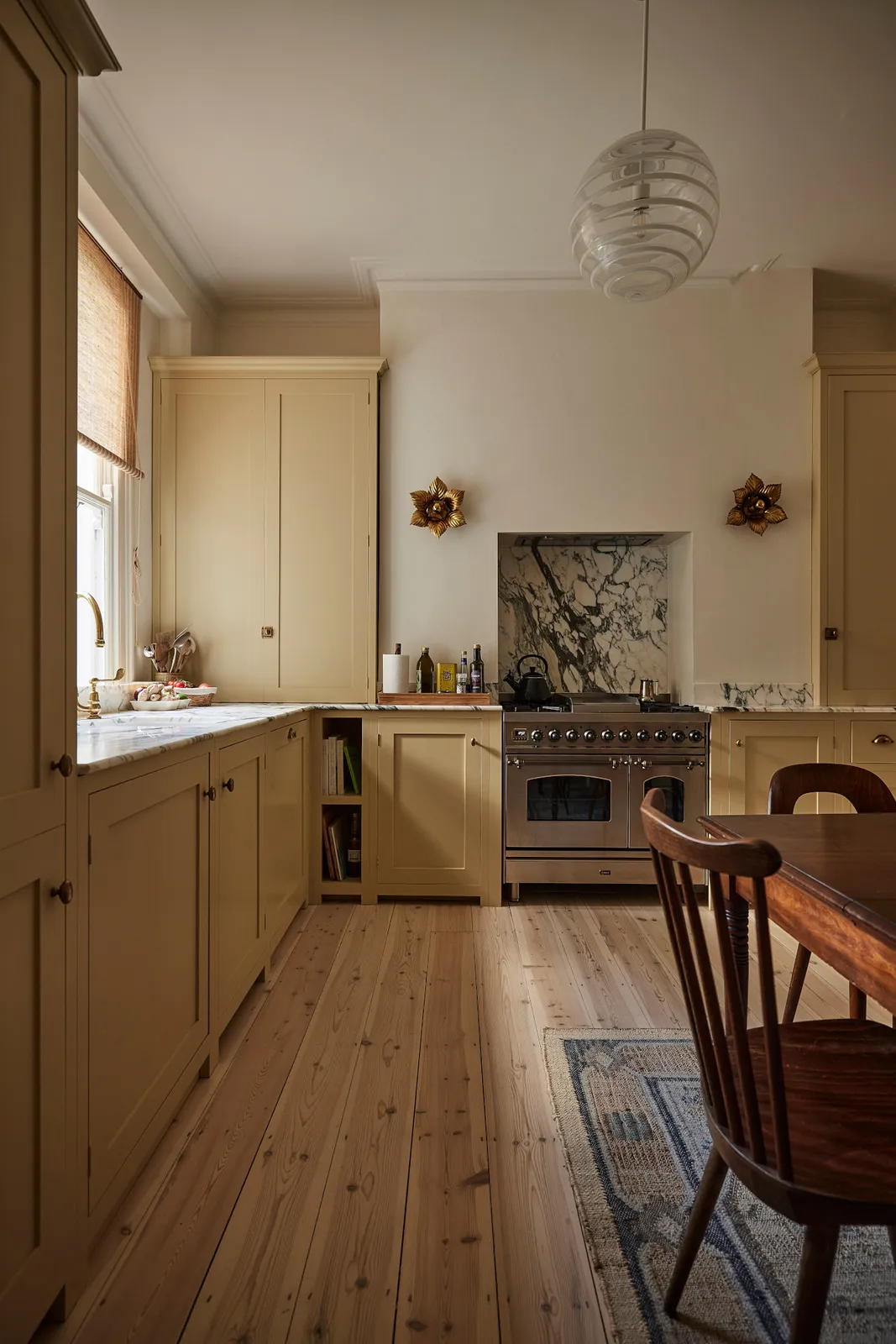 Warm beige cabinets run beneath a bright window beside a small dining table