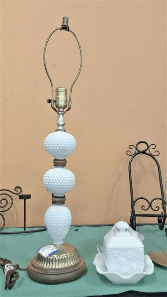 A vintage-style lamp with three pale textured sections and a metal base awaits a shade.