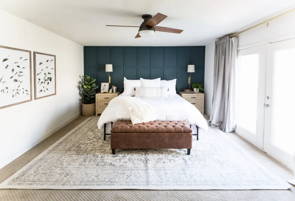 Deep blue rectangular panels sit behind a pale bed and brown bench