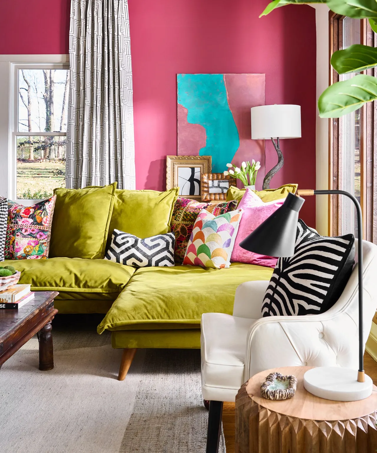 A lime-green sofa sits against pink walls beside black-and-white patterned cushions.