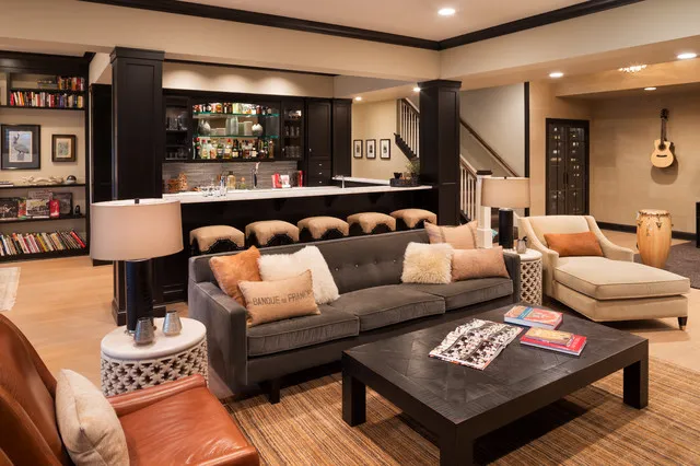 Gray sofa and pale chair around a broad dark coffee table in a warmly lit room