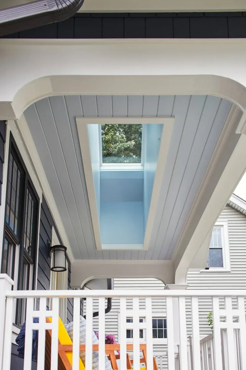 White porch ceiling with long glazed opening, pale blue recess and simple white railing below