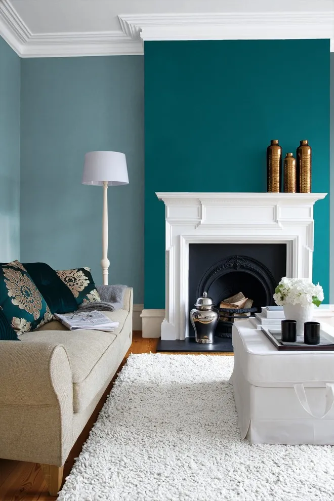 A teal painted section frames a white fireplace beside pale seating