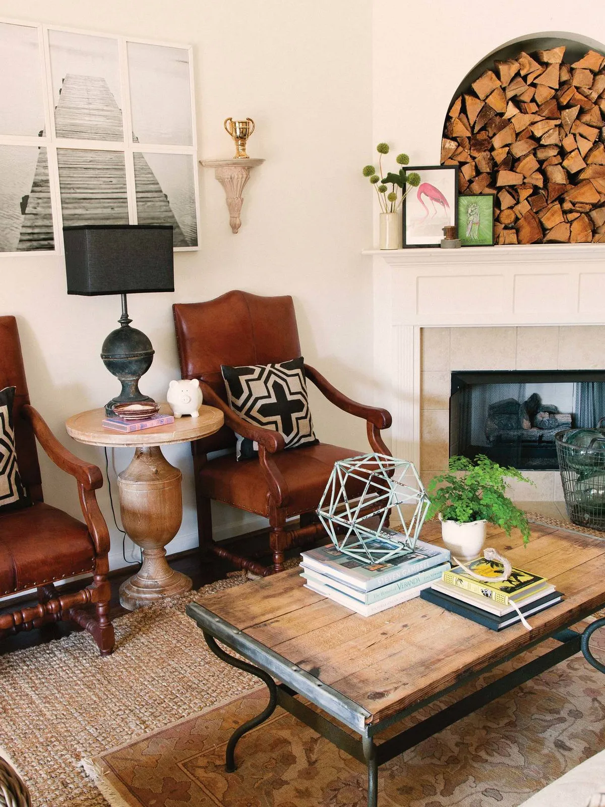 Traditional timber and leather chairs around a timber-topped coffee table beside a pale fireplace