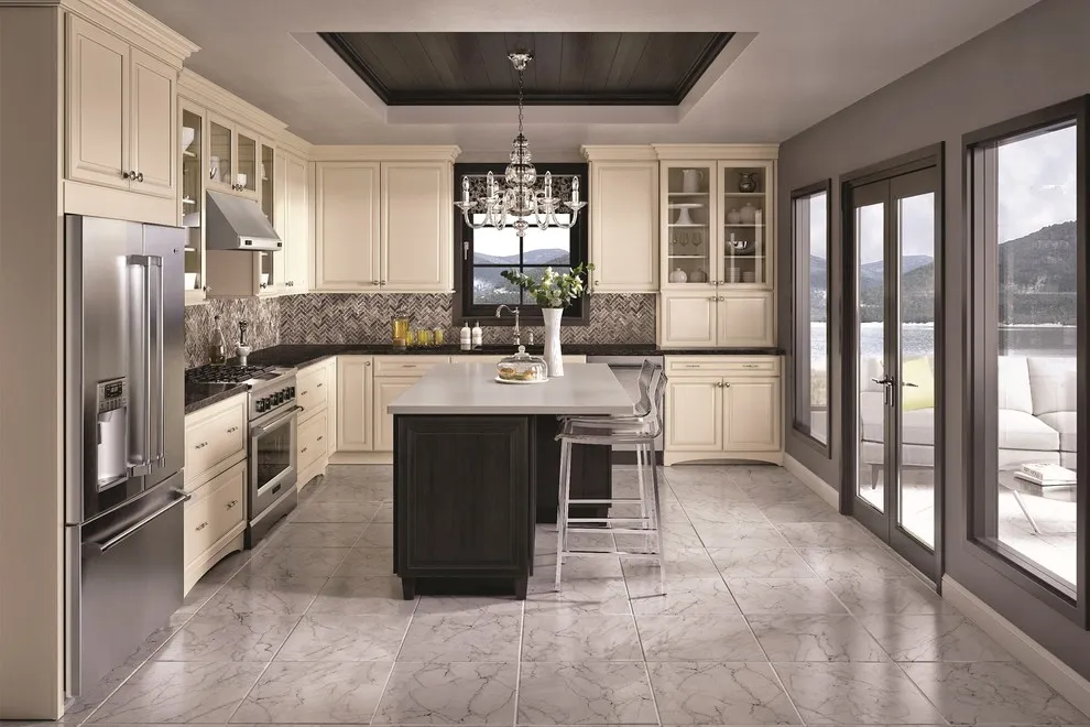 Cream cabinets surround a dark island beneath a dark ceiling inset beside black-framed windows