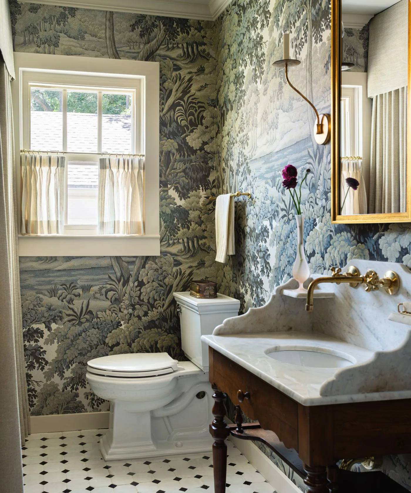 Powder room with landscape wallpaper, dark wood washstand, veined shaped basin and pale cafe curtain