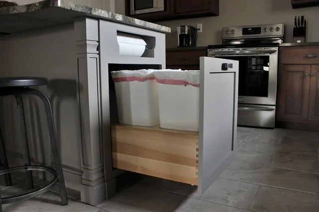 A dark pull-out cabinet reveals a timber drawer interior with space for a waste bin.