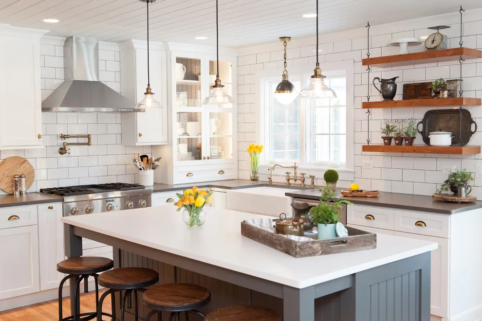 White cabinets sit beneath timber open shelves beside a blue-gray island with a pale counter