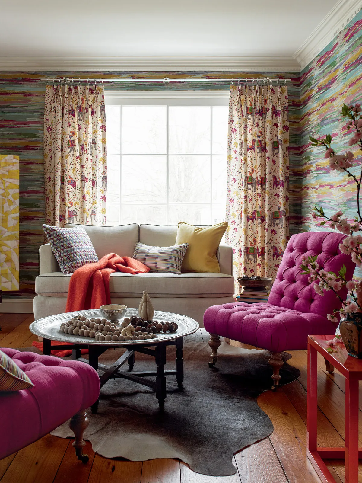 Purple tufted chairs sit beside a pale sofa and patterned curtains.