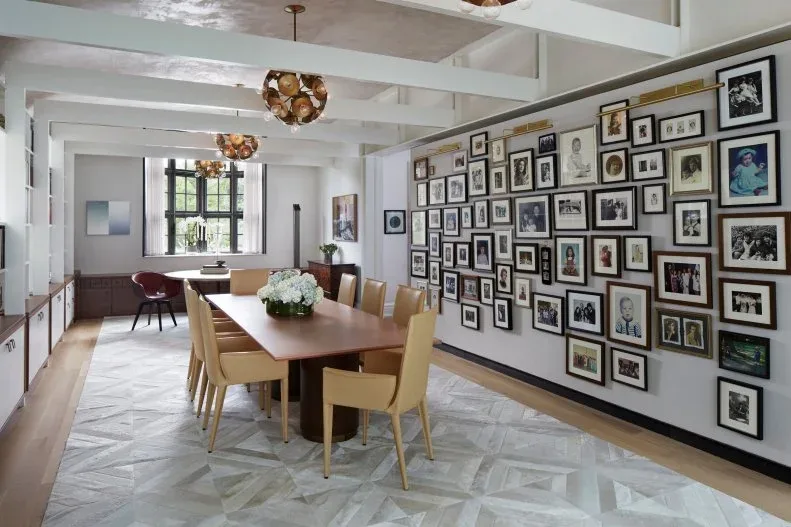 Long dining table with yellow chairs, a gallery wall and a smaller table near the back window
