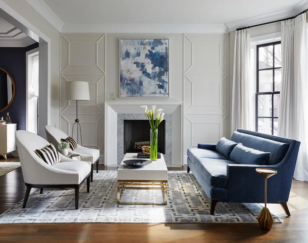 Pale chairs with striped cushions face a blue sofa across a light rug