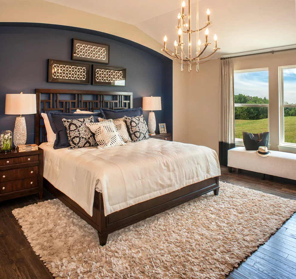 A dark blue wall follows an arched outline behind a traditional bed