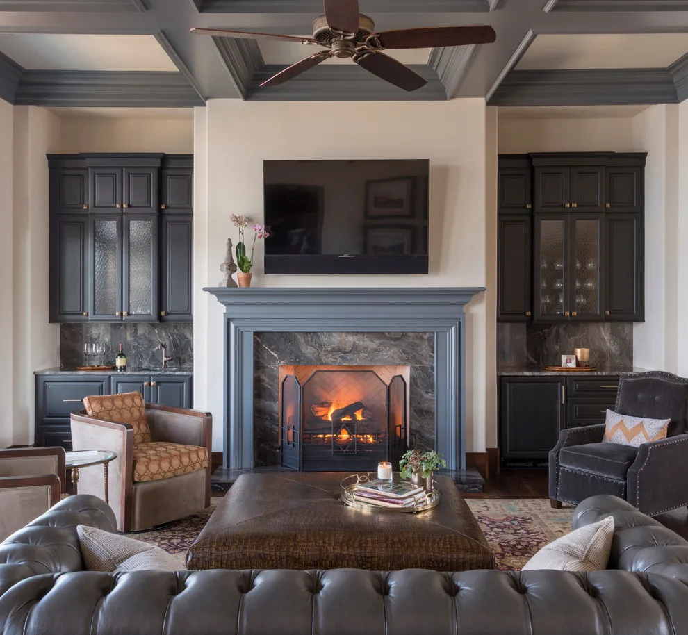 Gray seating faces a fireplace framed by darker cabinetry