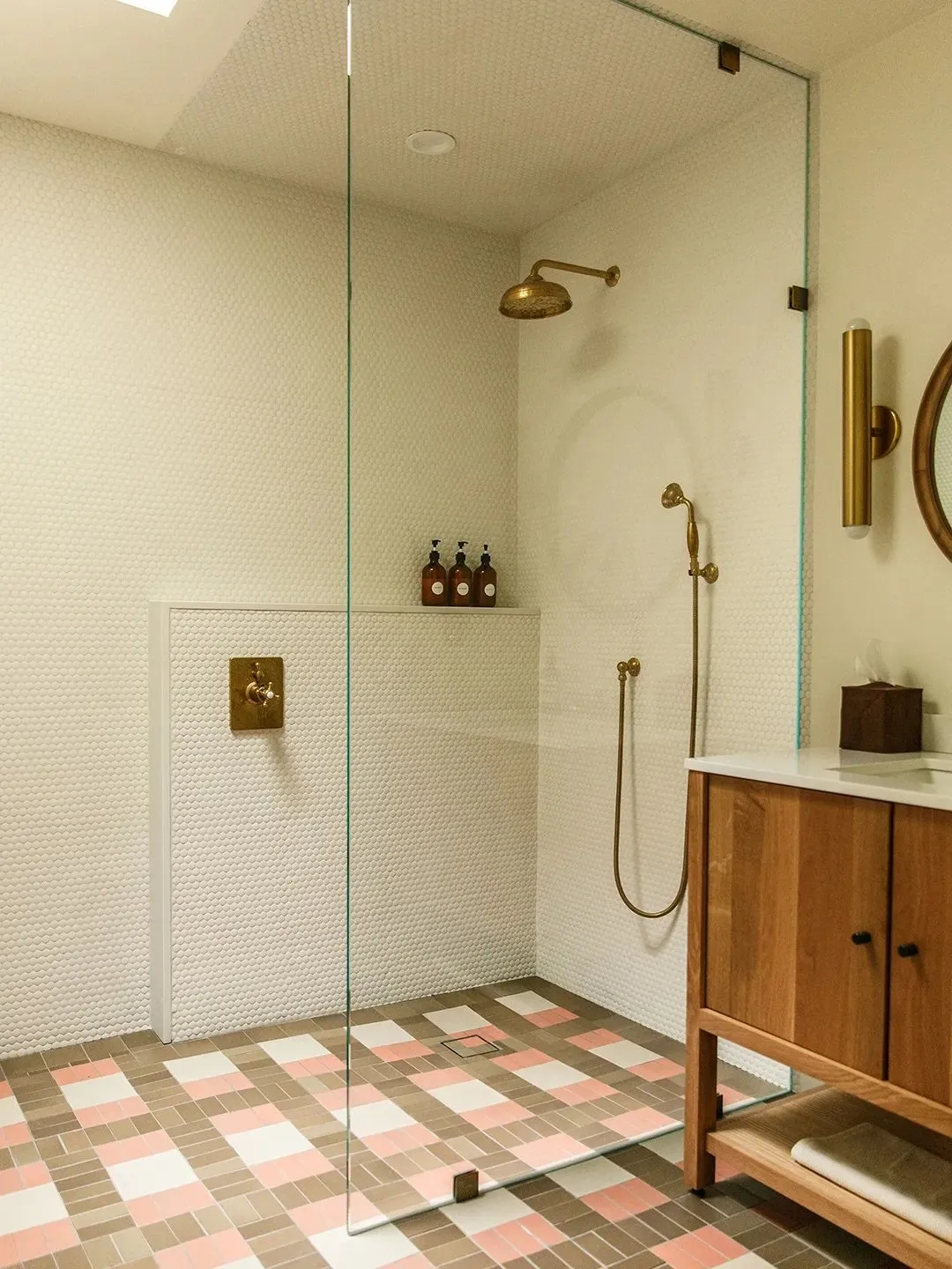 Pink, brown and cream squares cover the floor beside a timber vanity and glass shower