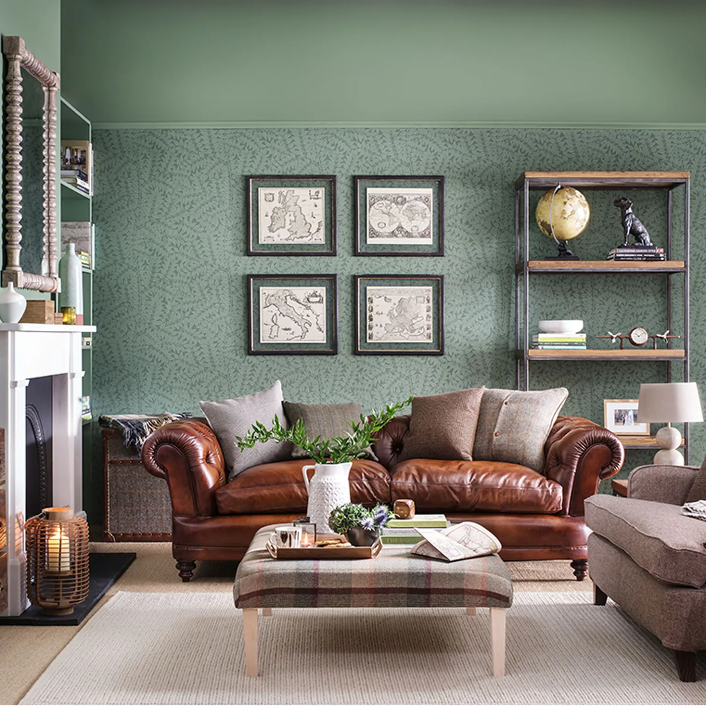 A brown tufted sofa sits below green patterned walls and four framed pictures beside a checked ottoman