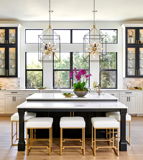 Dark glazed cupboards frame a bright kitchen window above a black island.