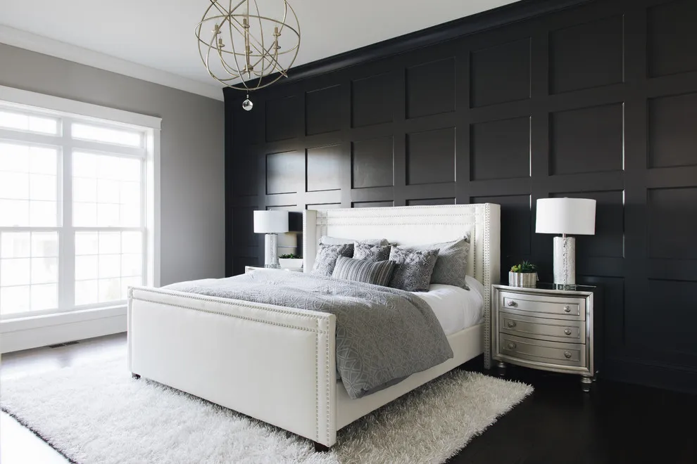 Black rectangular paneling sits behind a light upholstered bed and pale rug