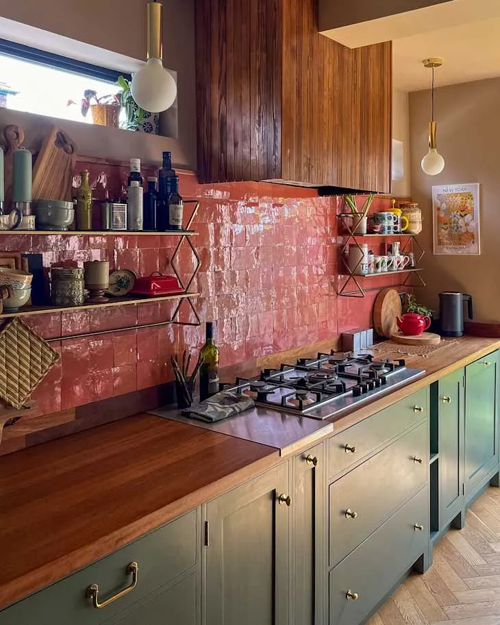 Collected cups, serving bowls and cutting boards on slim metal kitchen shelves above a warm timber counter