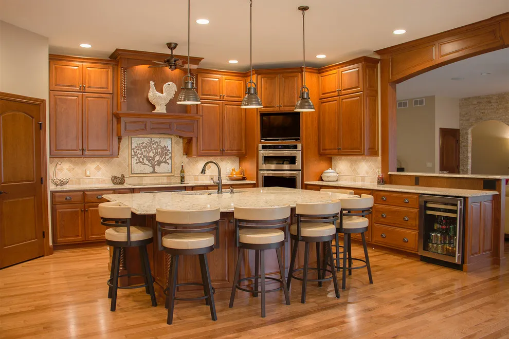 Warm wood cabinetry surrounds a rounded peninsula with upholstered stools