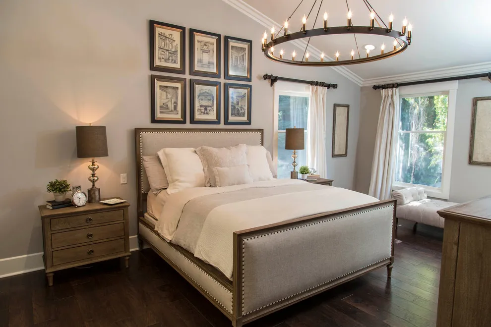 A light upholstered bed sits on a deep brown wood floor beside timber nightstands