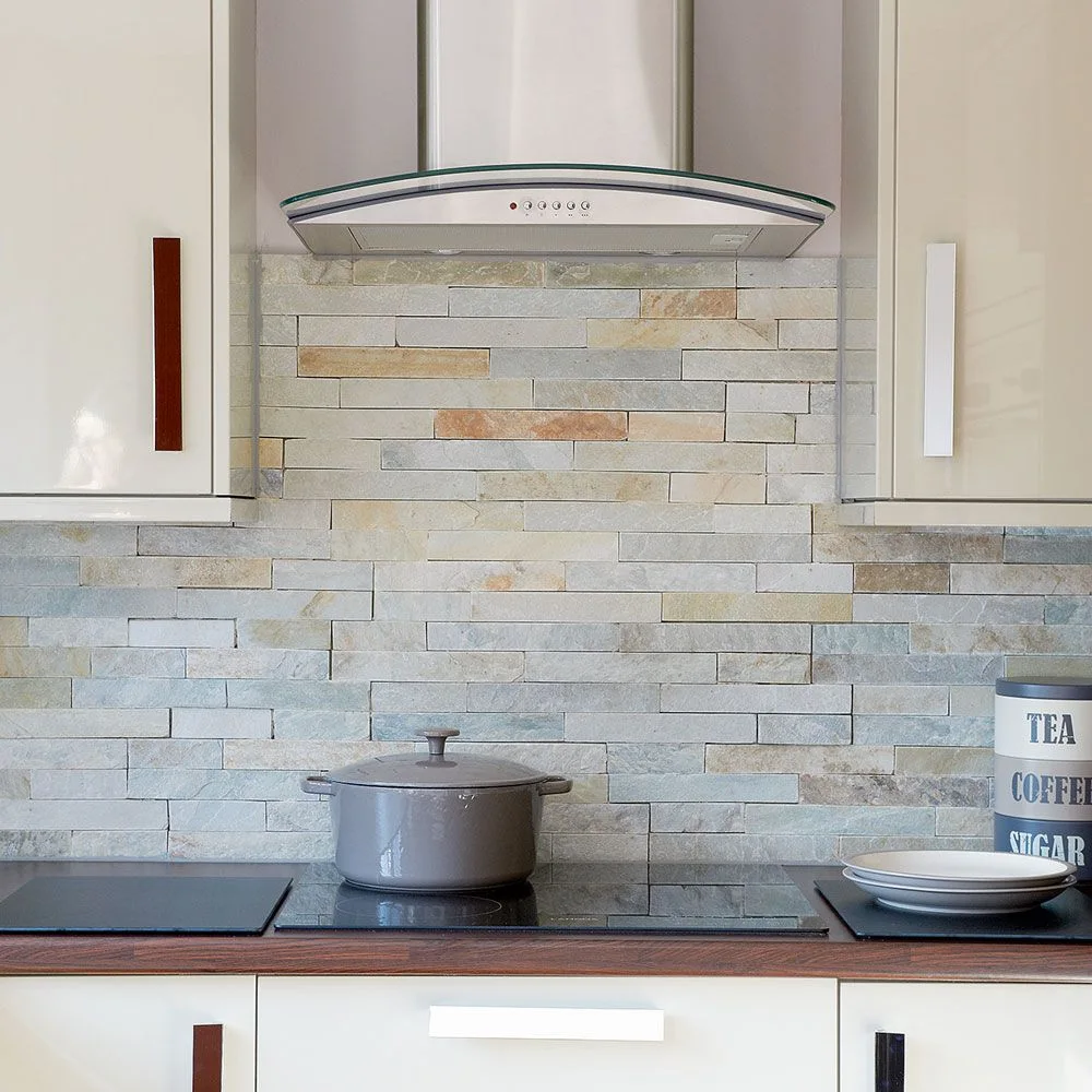 Narrow pale and warm-toned textured strips form a kitchen backsplash beneath a metal hood beside light cabinet doors