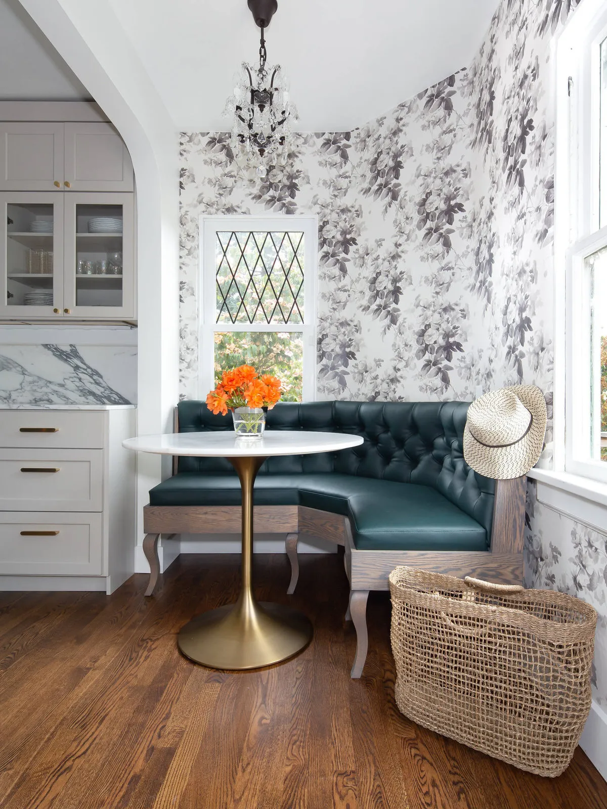 A dark upholstered banquette fits into a small nook beneath patterned walls.