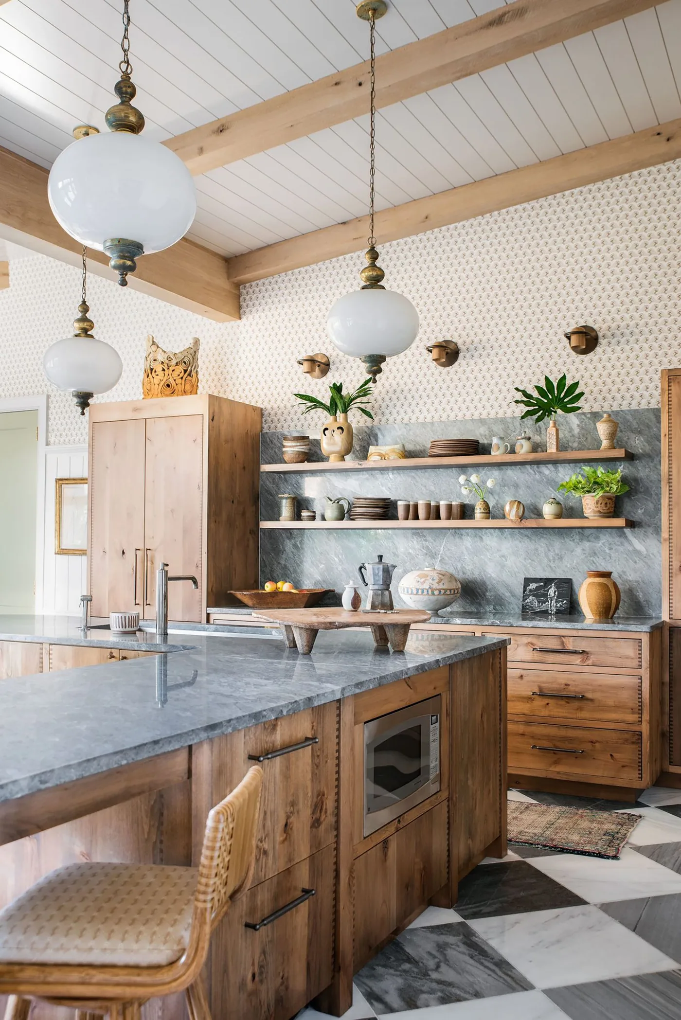 Wood-fronted kitchen with a checkerboard floor, globe pendants, open shelves and patterned upper walls.
