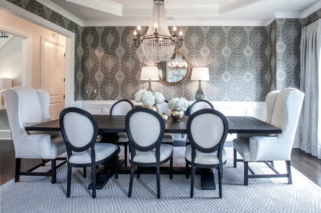 A bold gray patterned wall stands behind a dark dining table and pale oval-backed chairs.