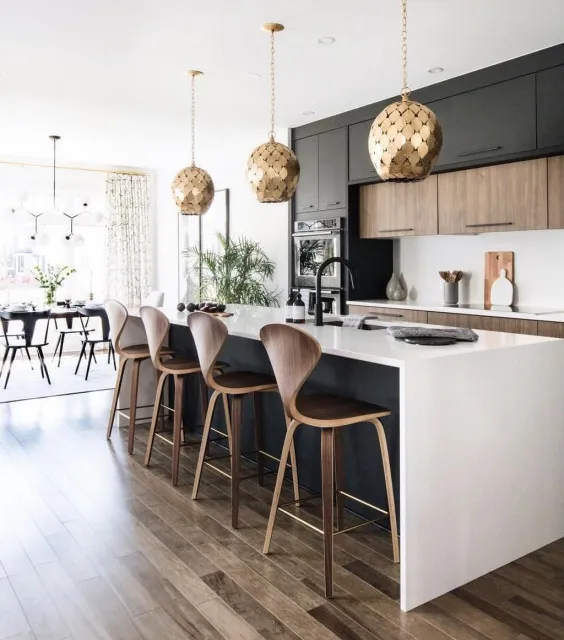 Dark upper cabinets and island seating contrast with a pale island end.