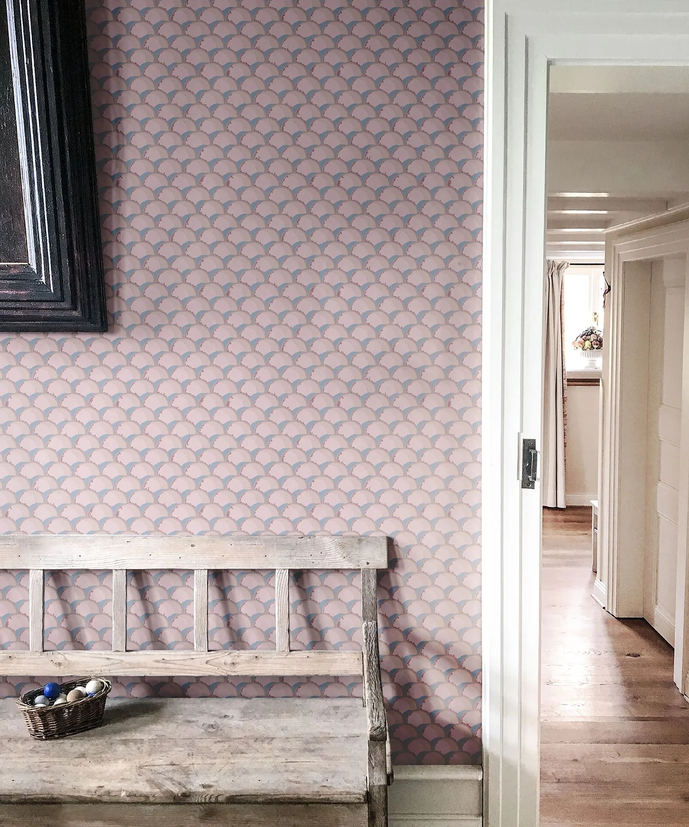 Entry detail with pink and blue fan-pattern wallpaper behind weathered wood bench