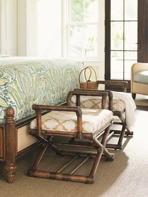 A timber-framed woven chair sits beneath a bright window with a pale cushion.