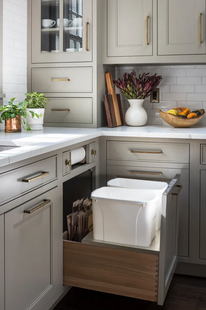 A beige cabinet opens to a pull-out waste bin beside the sink area