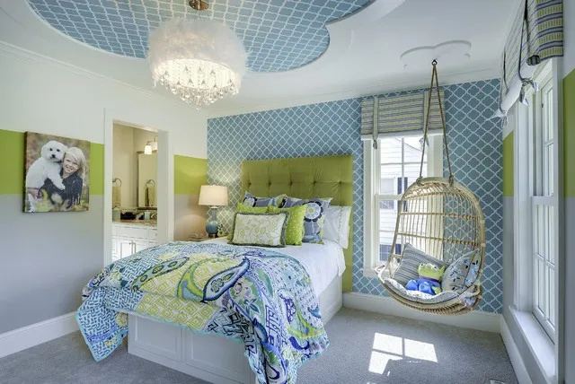Blue geometric wallpaper appears on the ceiling and wall behind a green upholstered bed.