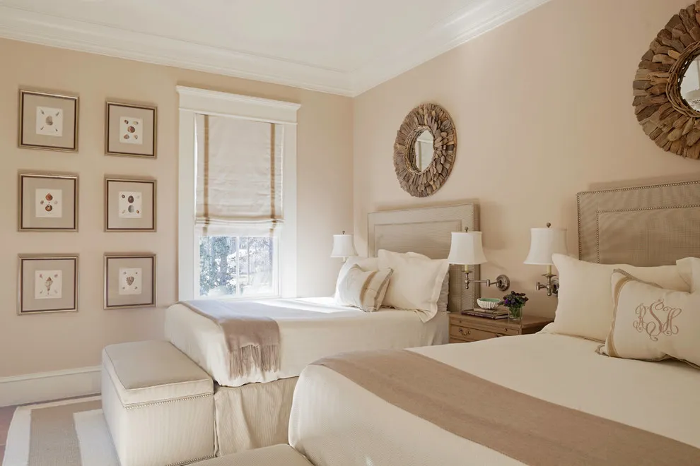 Two pale beds with beige throws sit beside a shared timber nightstand and a small upholstered bench