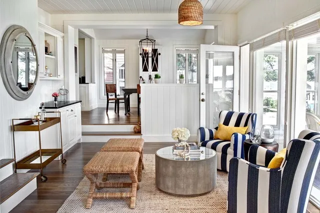 Blue-and-white striped chairs beside two small woven benches and a round metal table