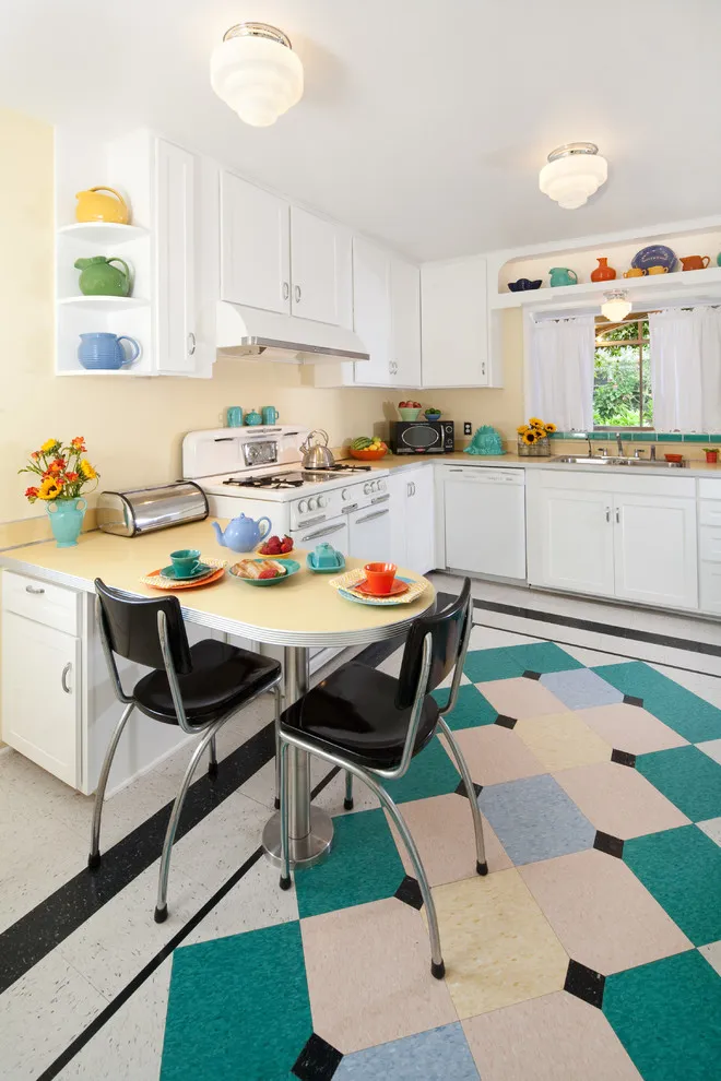 White cabinetry surrounds a small dining area beside a colorful geometric floor